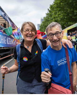 CSD Zweiertandem lachend  in die Kamera mit Gehstöcken Foto: Boaz Arad / Paritätischer Berlin