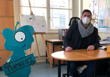 Ein Teamgeist-Werte-Alien im Büro der Schulleitung der Wedding Grundschule